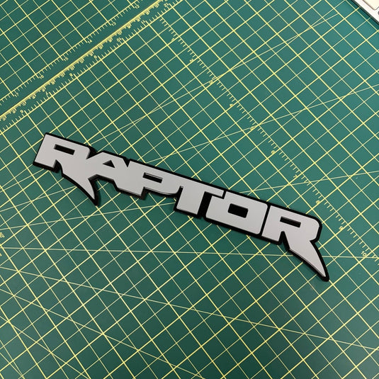Raptor emblem in light gray on green mat