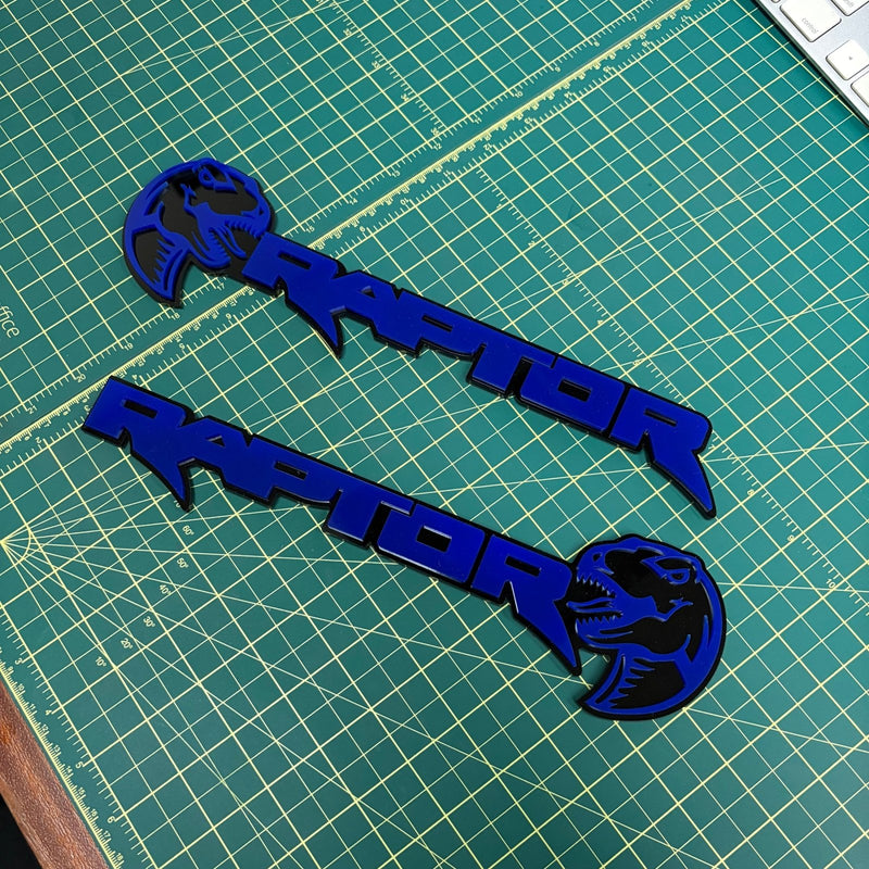 Load image into Gallery viewer, Two raptor emblems with dinosaur heads in deep blue

