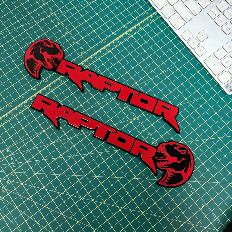 Load image into Gallery viewer, Pair of red raptor with dino head emblems on a green mat
