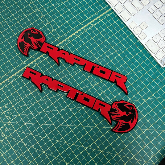 Pair of red raptor with dino head emblems on a green mat